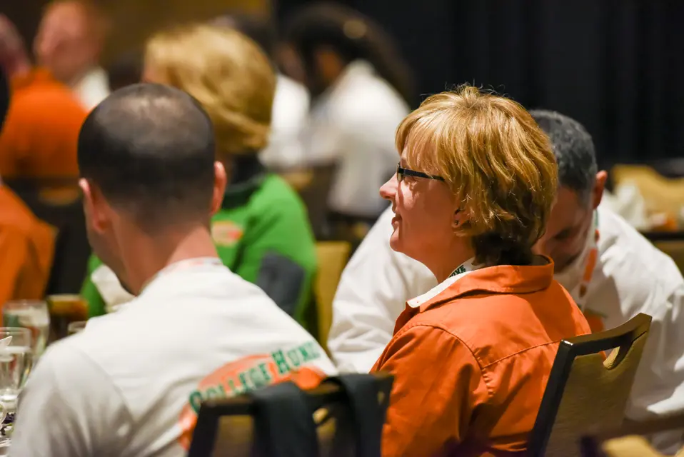 Franchise owner laughing during a general session at the College HUNKS reunion