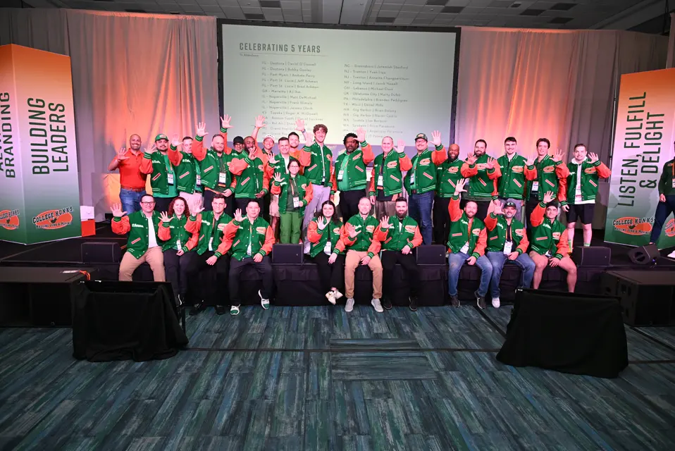 Franchise owners celebrating together on stage at the annual reunion