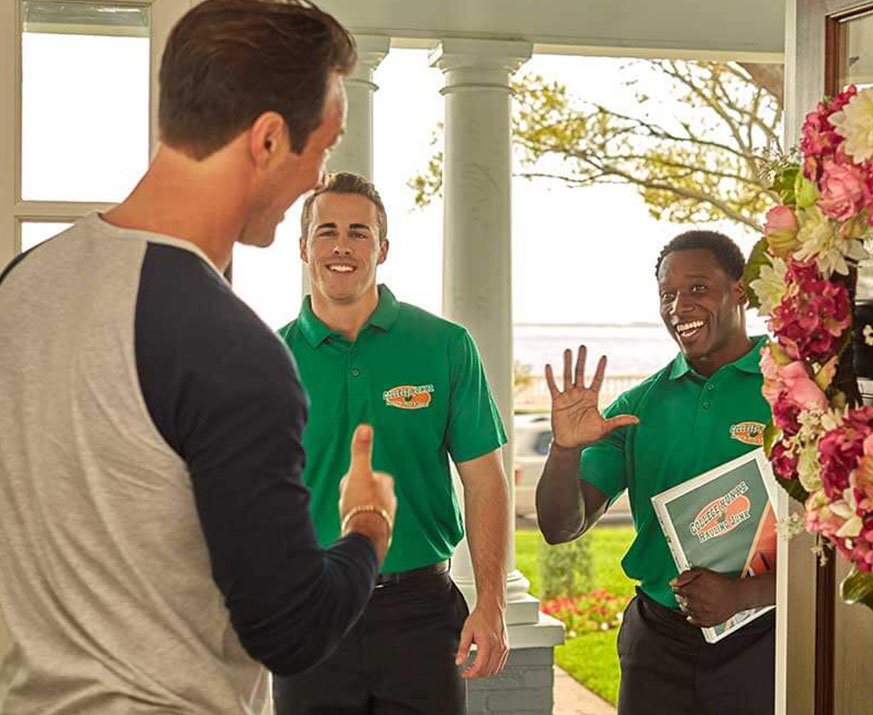 Uniformed junk removal crew with a satisfied customer, the repeat business a business plan has to forecast