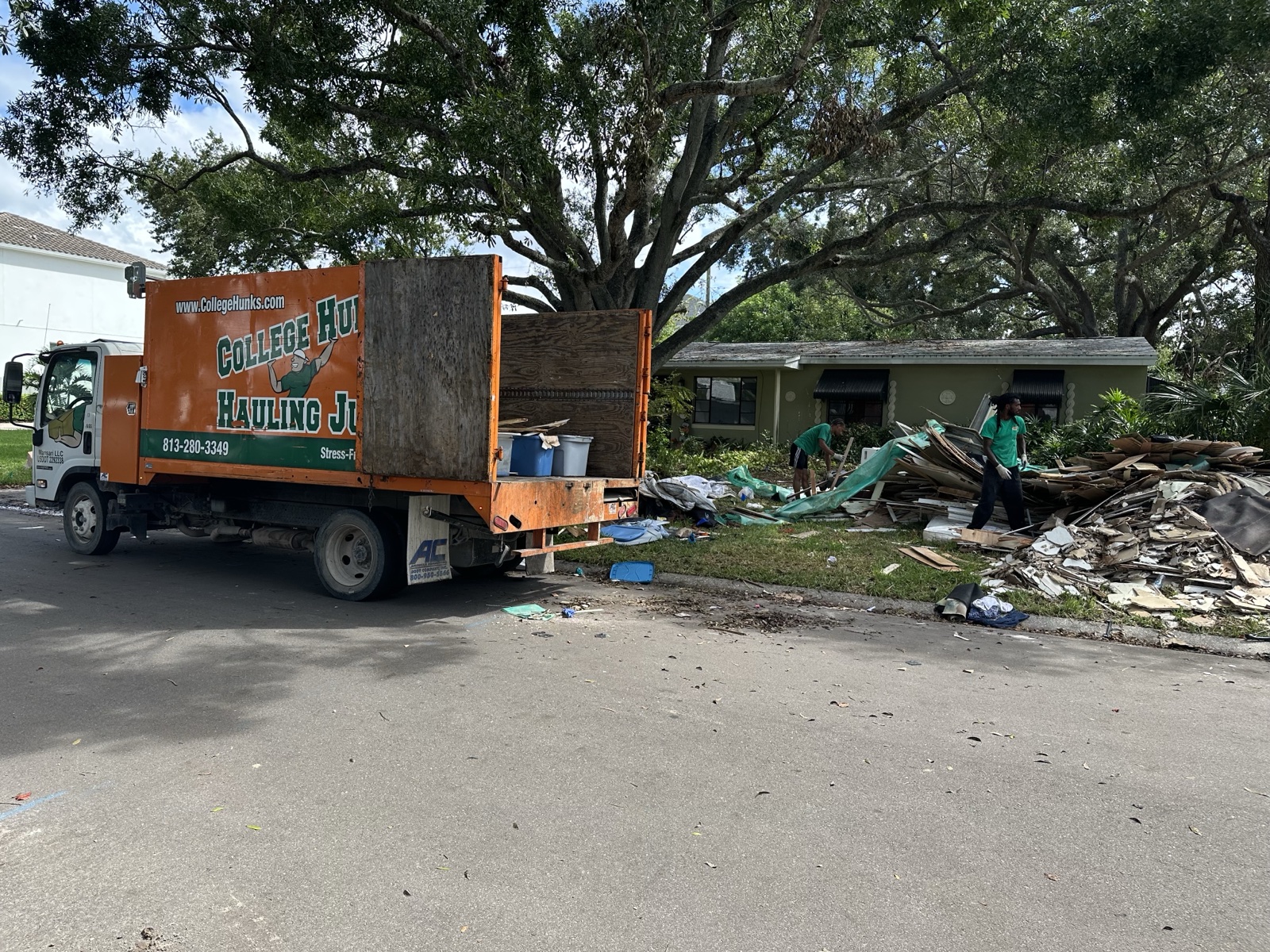 College HUNKS crew clearing a job site with the junk removal truck, the work at the center of a junk franchise