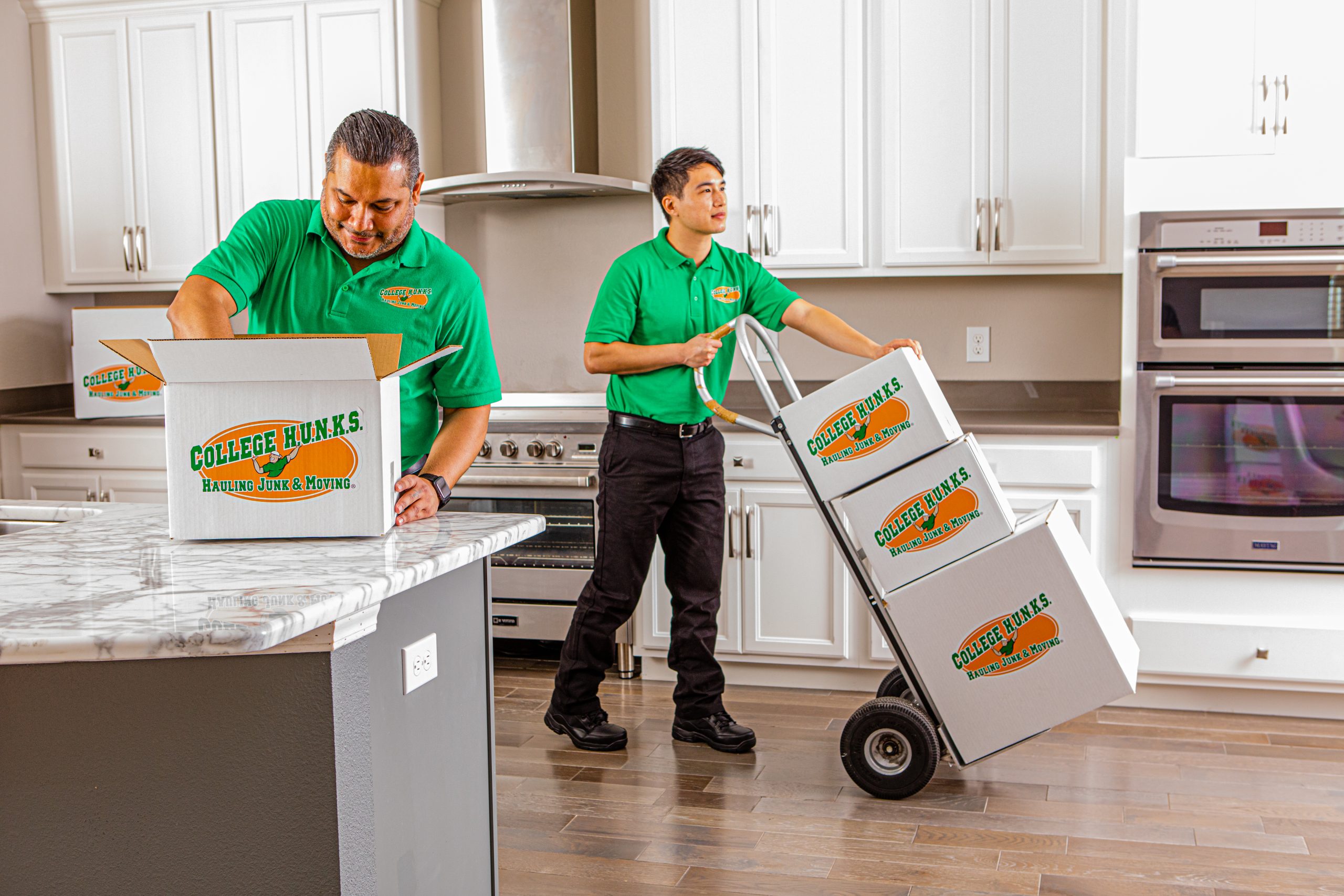 College HUNKS moving crew carrying branded boxes in a home