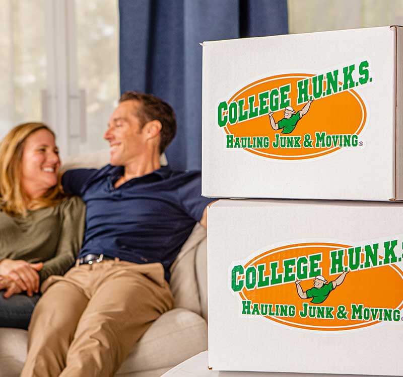 Homeowners with branded College Hunks moving boxes, the kind of daily job a ROBS-funded franchise pays for